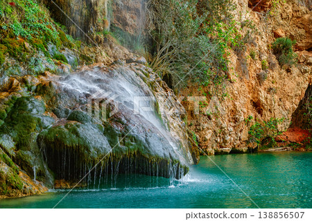 A Tranquil Waterfall Cascading Over Mossy Rocks in a Serene Natural Landscape A Tranquil Waterfall Cascading Over Mossy Rocks in a Serene Natural Landscape 138856507