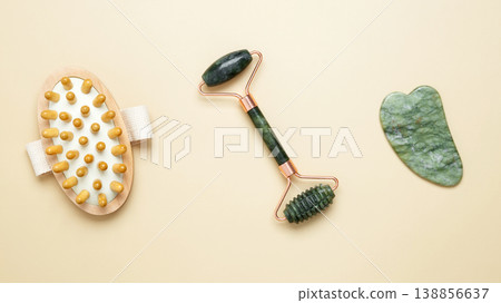 Skincare tools including marble roller, gua sha, and wooden brush arranged for relaxation and self-care Skincare tools including marble roller, gua sha, and wooden brush arranged for relaxation and self-care 138856637