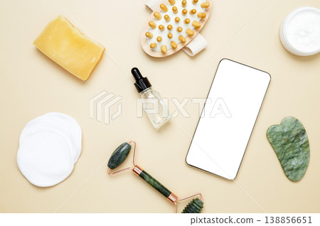 Smartphone mockup with skincare products including marble face roller, gua sha, wooden body brush, facial cream and serum arranged Smartphone mockup with skincare products including marble face roller, gua sha, wooden body brush, facial cream and serum arranged 138856651