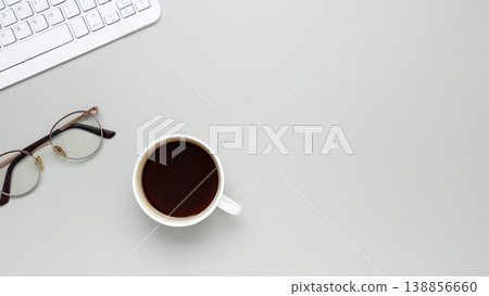 Comfortable workspace setup with coffee cup, keyboard, glasses supporting productive morning routine 138856660