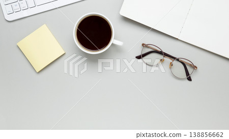 Cozy workspace with coffee, keyboard, glasses, and notebook setting a focused morning mood 138856662