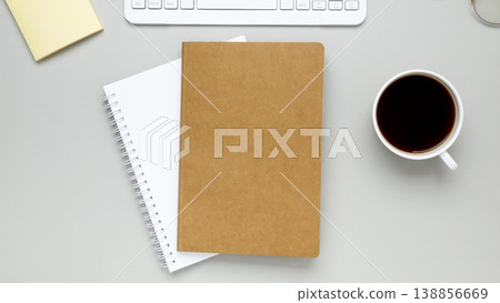 Simple desk arrangement with coffee cup, eyeglasses and notebook forming quiet concentrated work setting 138856669