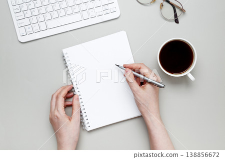 Woman writing notes notebook coffee supporting planning focus work routine Woman writing notes notebook coffee supporting planning focus work routine 138856672