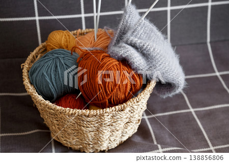 Basket holding vibrant yarn balls prepared for knitting and crafting projects Basket holding vibrant yarn balls prepared for knitting and crafting projects 138856806