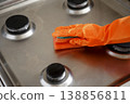 Woman wipes washed clean gas stove with sponge in kitchen 138856811