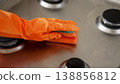 Woman cleaning gas stove with sponge in kitchen after washing 138856812