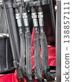Hydraulic hoses connected to machinery for lifting and moving heavy loads in a workshop setting 138857111