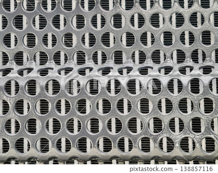 Texture of a metal grate showing circular holes arranged in a repeating pattern with a smooth surface Texture of a metal grate showing circular holes arranged in a repeating pattern with a smooth surface 138857116