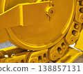 Close view of yellow construction equipment showing tracks and wheels working on a project site during the day 138857131