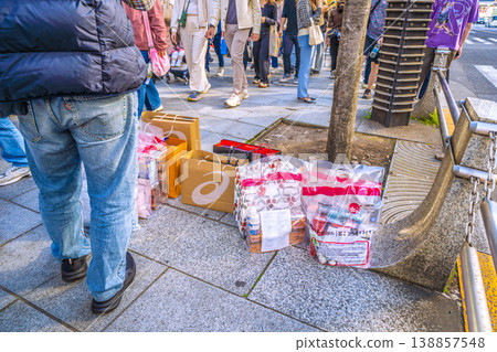 東京都市的「購物狂潮」再次上演……外國男子在一家大型藥妝店前站崗……他們的「戰利品」整齊地排列著。 138857548