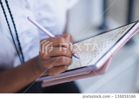 Close up of hand using stylus on tablet with digital planner interface. Schedule management, note taking, online organization, remote work, data entry and productivity concept. 138858166