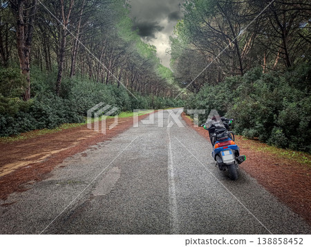 Motor scooter parked on the edge of an empty road 138858452