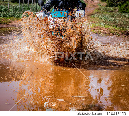 Adventure motorcycle wading across a brown puddle 138858453
