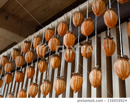 Dried persimmons hanging from the eaves of a house 138858924