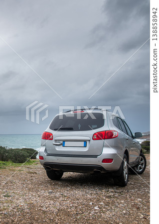 Vertical View of SUV on Coastal Dirt Road during Stormy Sea Vertical View of SUV on Coastal Dirt Road during Stormy Sea 138858942