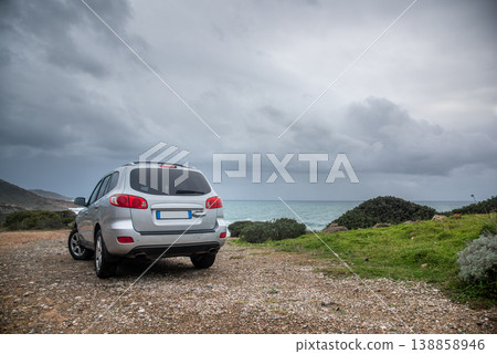 SUV Parked on Dirt Road by the Coast during Stormy Sea SUV Parked on Dirt Road by the Coast during Stormy Sea 138858946