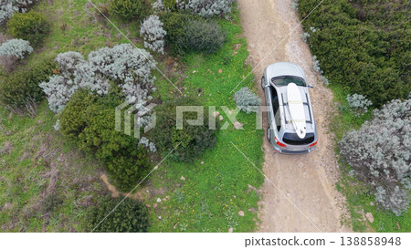 Overhead View of SUV with Surfboard on White Road with Vegetation on Left Overhead View of SUV with Surfboard on White Road with Vegetation on Left 138858948