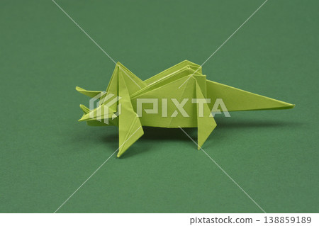 Green origami triceratops on dark green background 138859189