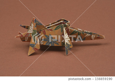 Handmade floral origami triceratops on brown background 138859190