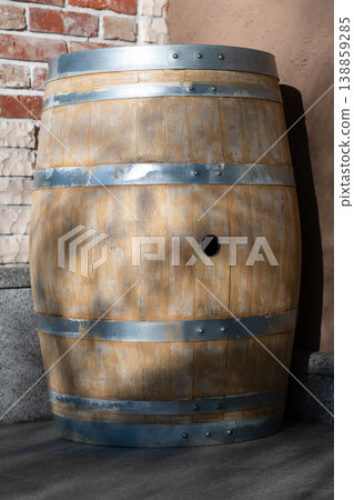 A rustic wooden barrel with metal bands and a bung hole. Vertical shot A rustic wooden barrel with metal bands and a bung hole. Vertical shot 138859285