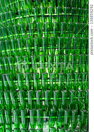 Background of empty green glass bottles. Vertical shot . 138859292