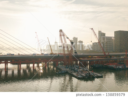 Aerial view of bridge sections being dismantled with a large crane over a river Aerial view of bridge sections being dismantled with a large crane over a river 138859379