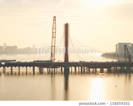 Aerial view of bridge sections being dismantled with a large crane over a river Aerial view of bridge sections being dismantled with a large crane over a river 138859381