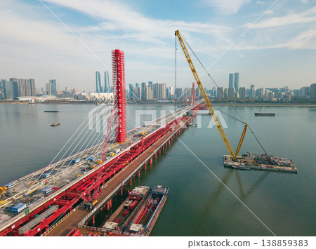 Aerial view of cranes and construction equipment are working to dismantle an old cable stayed bridge. Aerial view of cranes and construction equipment are working to dismantle an old cable stayed bridge. 138859383