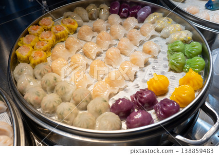 Colorful Assortment of Dim Sum in a Steamer Basket at a Vibrant Asian Night Food Market Colorful Assortment of Dim Sum in a Steamer Basket at a Vibrant Asian Night Food Market 138859483