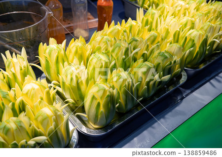 Vibrant Display of Artfully Carved Lotus Flowers at an Asian Night Food Street Market in China Vibrant Display of Artfully Carved Lotus Flowers at an Asian Night Food Street Market in China 138859486