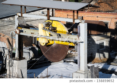 Large industrial circular saw machine at an outdoor stone processing facility. Heavy equipment used for cutting stone or concrete Large industrial circular saw machine at an outdoor stone processing facility. Heavy equipment used for cutting stone or concrete 138859652