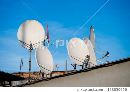 Multiple satellite dishes above the roof . Internet Protocol Television and Cable television concept . 138859656
