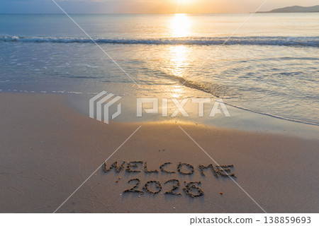 Welcome 2026 written in the sand on the beach at sunset, with the sea and horizon in the background Welcome 2026 written in the sand on the beach at sunset, with the sea and horizon in the background 138859693