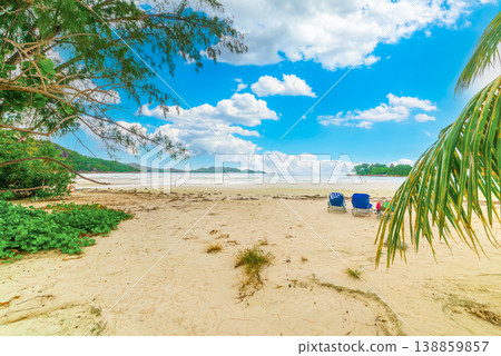 beach chairs in a tropical beach under a blue sky with clouds beach chairs in a tropical beach under a blue sky with clouds 138859857