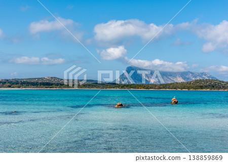 Turquoise Water at Lu Impostu Beach with Two Rocks under Blue Sky on a Sunny Day Turquoise Water at Lu Impostu Beach with Two Rocks under Blue Sky on a Sunny Day 138859869