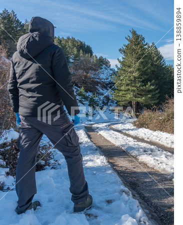 Man Seen from Behind Standing on Snowy Mountain Road Man Seen from Behind Standing on Snowy Mountain Road 138859894