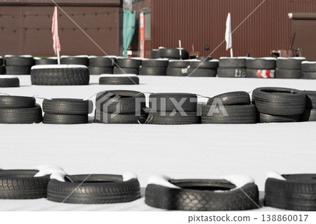 Racetrack fence . Old tires on a kart racing track  . 138860017