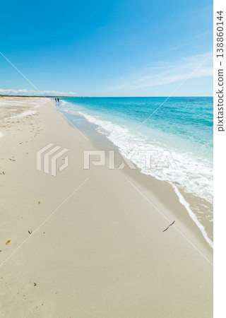 Vertical Sardinian Beach with Turquoise Water and White Sand, Distant Couple Walking Vertical Sardinian Beach with Turquoise Water and White Sand, Distant Couple Walking 138860144