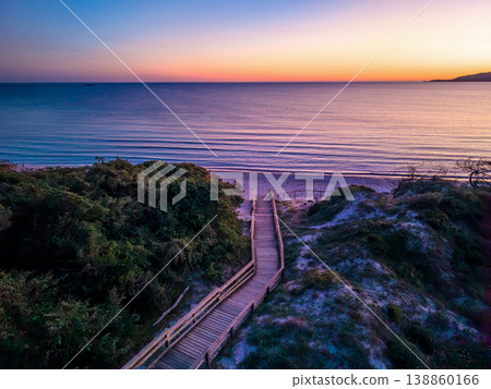 Aerial view of a wooden boardwalk leading through coastal dunes to Maria Pia beach Aerial view of a wooden boardwalk leading through coastal dunes to Maria Pia beach 138860166