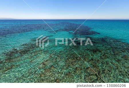 Aerial view of crystal clear turquoise water under a blue sky Aerial view of crystal clear turquoise water under a blue sky 138860206