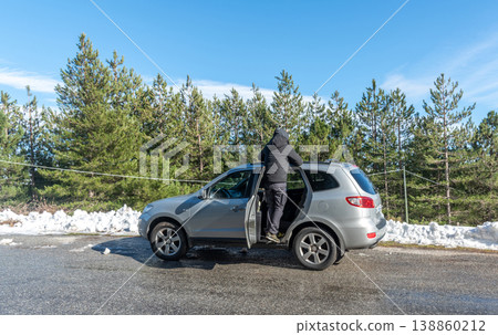 Man Standing on a SUV to View Mountain Landscape Seen from Behind Man Standing on a SUV to View Mountain Landscape Seen from Behind 138860212
