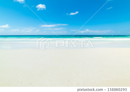 White sand tropical beach with turquoise water under a blue sky with small clouds 138860293