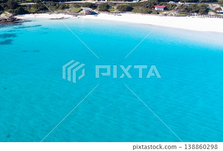 Aerial view of a white sand beach seen from the water on a sunny day Aerial view of a white sand beach seen from the water on a sunny day 138860298