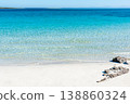White sand beach with turquoise water and some rocks under a clear sky. 138860324