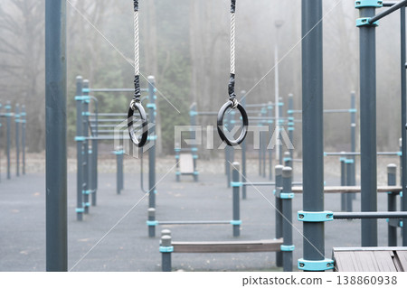 Gymnastic rings on outdoor sports ground . Fitness equipment detail Gymnastic rings on outdoor sports ground . Fitness equipment detail 138860938
