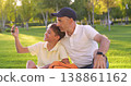Happy father and son take selfie on smartphone in park. Happy dad and child enjoy family time outdoors. Parenting bond and joyful leisure on sunny day. Happy family. 138861162