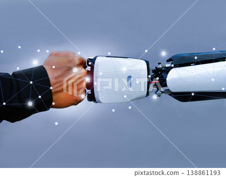 Human and robot fist bump against digital network background, representing future collaboration between man and artificial intelligence 138861193