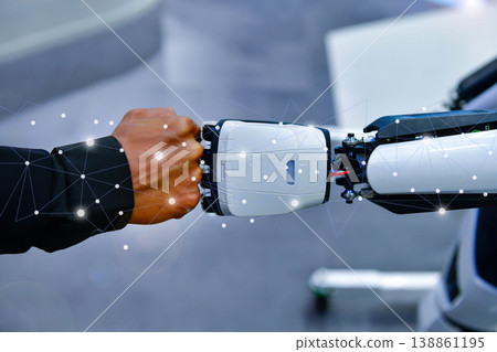Human and robot fist bump against digital network background, representing future collaboration between man and artificial intelligence 138861195