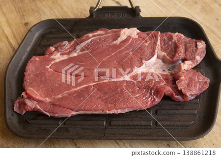 Raw beef chuck steak on cast iron griddle 138861218