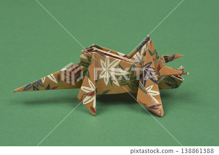 Handmade floral origami triceratops on green background 138861388